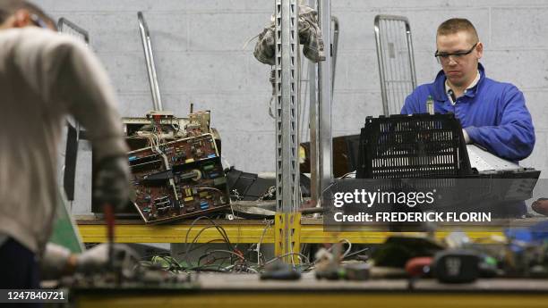 Employees sort electronic components from television sets at a recycling plant 09 November 2006 in Strasbourg, eastern France. Des employés trient...