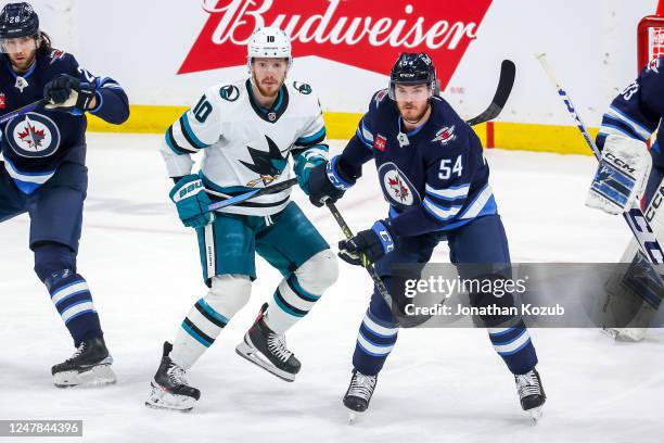 Evgeny Svechnikov of the San Jose Sharks and Dylan Samberg of the Winnipeg Jets keep an eye on the play during first period action at the Canada Life...