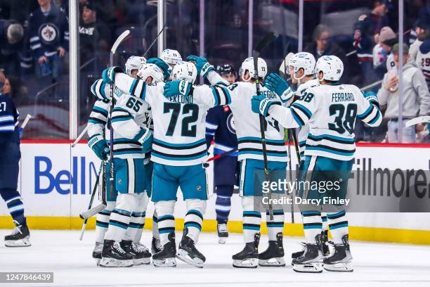 San Jose Sharks players celebrate on the ice following a 3-2 overtime victory over the Winnipeg Jets at the Canada Life Centre on March 6, 2023 in...
