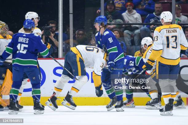 Cole Smith of the Nashville Predators is checked by Vitali Kravtsov of the Vancouver Canucks during the second period of their NHL game at Rogers...