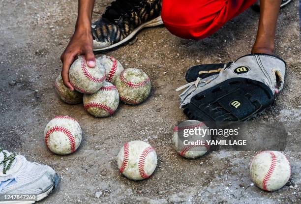 Boy picks up balls during a baseball training class in Havana, on March 6, 2023. - The 2023 World Baseball Classic begins March 7, 2023 when the...