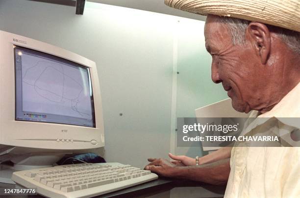 Fabian Padilla draws a line in one of the computers of Little Intelligent Communities 04 August 2000 at the inauguration of the project in El Rodeo,...