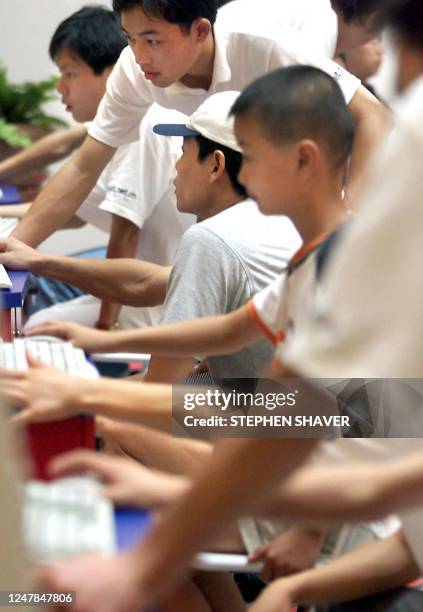 Eager arms of first-time Chinese surfers navigate on mouses and keyboards, 31 August 2000 while surfing the net during a promotional expo by a new...