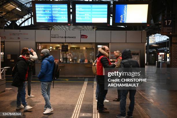 Employees give informations to travellers at the Gare de l'Est railway station in Paris, on March 7 as fresh strikes and protests are planned against...