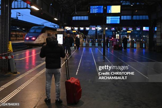 Traveller stands near platforms at the Gare de l'Est railway station in Paris, on March 7 as fresh strikes and protests are planned against the...