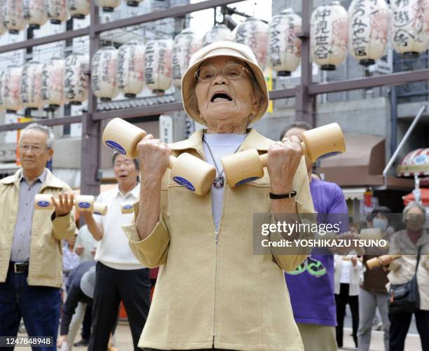 Elderly people work out with wooden dumb-bells in the grounds of a temple in Tokyo on September 21, 2009 to celebrate Japan's...