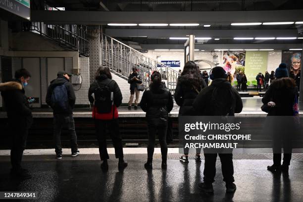 Commuters wait for their train at the Gare de l'Est metro station in Paris, on March 7, 2023. -