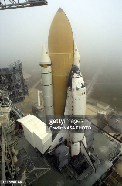 The US space shuttle Discovery is transported to the top of launch pad 39-B at the Kennedy Space Center 12 February 2001 in Florida while the US...