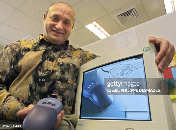 Israeli scientist Roman Gouzman displays in Jerusalem 23 January 2001 the computer mouse he helped invent to help the blind "see" computer graphics,...