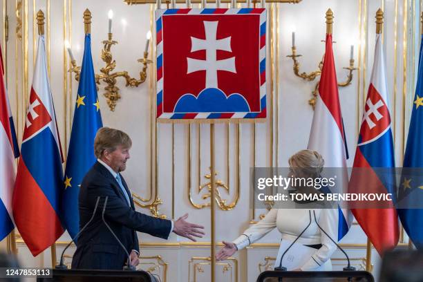 The President of Slovakia Zuzana Caputova and King Willem-Alexander of the Netherlands shake hands at the end of a media briefing at the presidential...