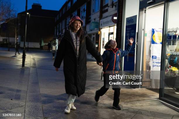 Ukrainian refugee Yevhenia Shymshyrian laughs as her 10-year-old son Gregory jokes around on their walk home from his school on March 6, 2023 in...
