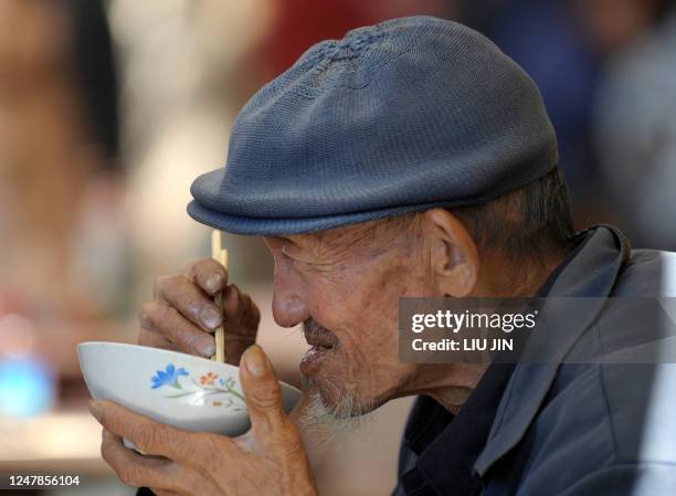 Population-demographics-world-China,FOCUS by Pascale TROUILLAUD This picture taken on October 24, 2011 shows an elderly man having his lunch in...