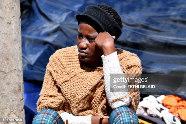 Migrant gestures in a makeshift camp site outside the headquarters of the International Organisation for Migration in Tunis, on March 7, 2023. -...