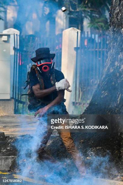 Demonstrator throws back a tear gas canister fired by police to disperse anti-government demonstrators and university students during a protest...