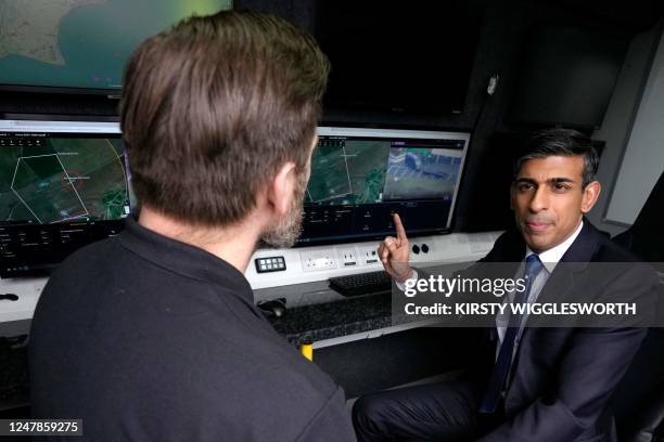 Britain's Prime Minister Rishi Sunak, , speaks to a member of Home Office contracted staff, during a visit to a Home Office joint control room in...