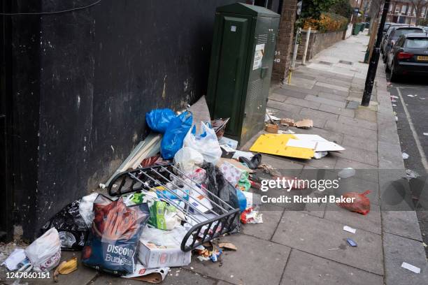 Packaging litter and food waste is spread across the pavement in a Cricklewood side street, on 6th March 2023, in London, England.