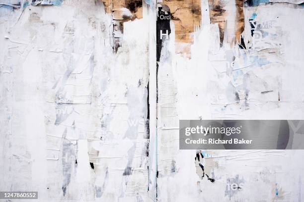 Detail of a peeling, split surface of a property's hoarding that represents closure and decay over the years in Cricklewood, on 6th March 2023, in...