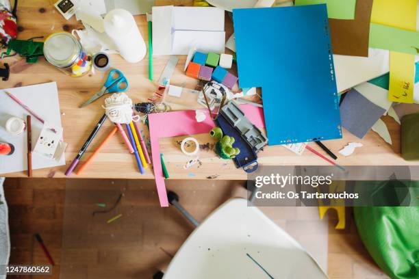 messy desk with craft materials - kunstnijverheid stockfoto's en -beelden