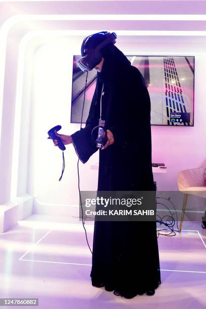 Woman tries on a virtual reality set during the World police Summit 2023 in Dubai on March 7, 2023.