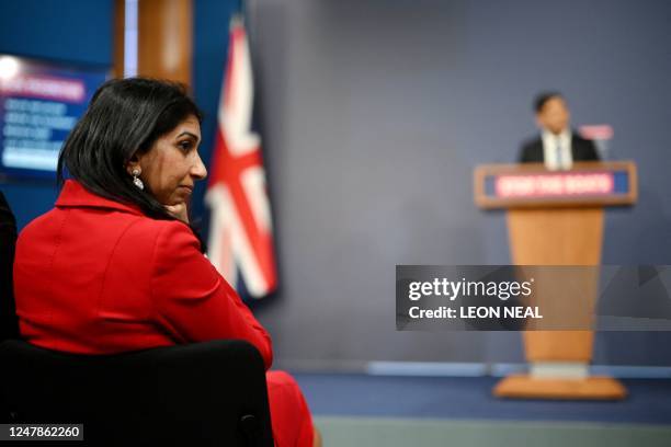 Britain's Home Secretary Suella Braverman listens as Britain's Prime Minister Rishi Sunak speaks during a press conference in the Downing Street...