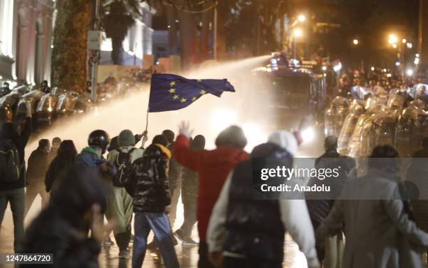 Riot police use water cannon and tear gas to disperse protesters gathered outside parliament building during a protest against bill on foreign...