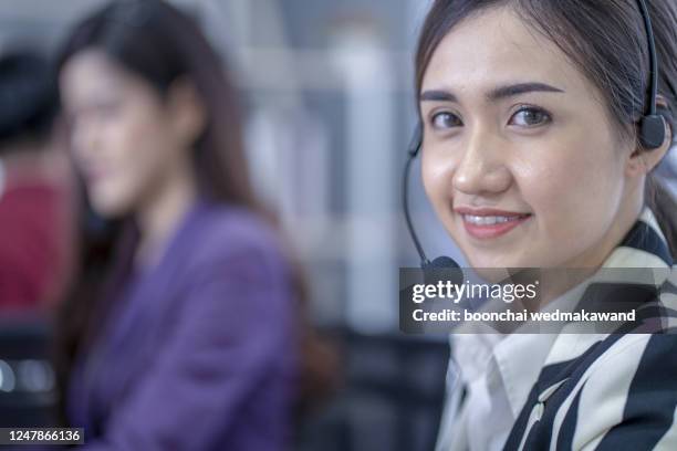 attractive smiling positive young businesspeople and colleagues in a call center office - office cross section stock pictures, royalty-free photos & images