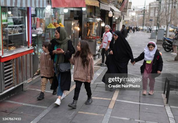 Iranian schoolgirls walk with their mothers along a street-side in downtown Tehran, March 7, 2023. The world will be celebrating the International...