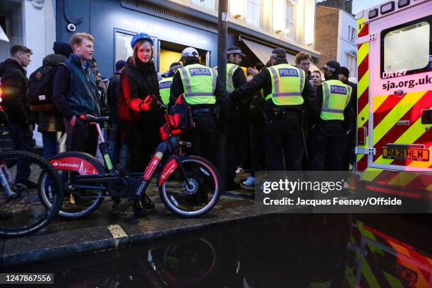 Passers by are held up as police keep Chelsea fans held back ahead of the UEFA Champions League round of 16 leg two match between Chelsea FC and...