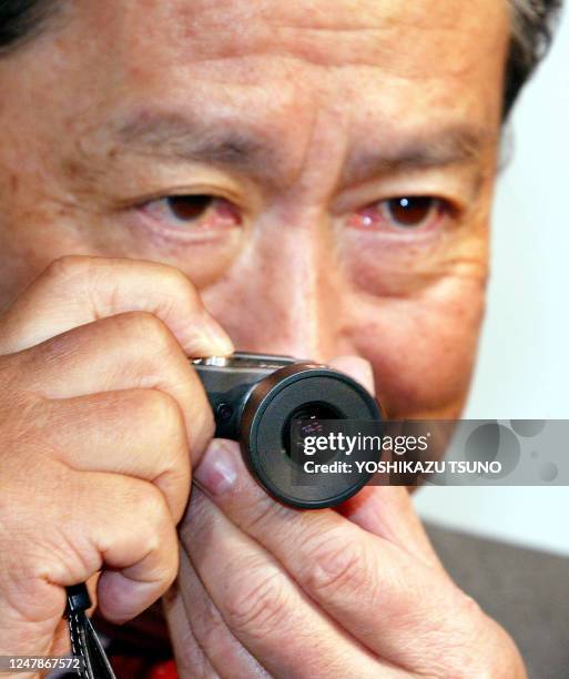 Japan's electronics giant Sony Chairman and CEO Nobuyuki Idei shows off the new micro sized digital still camera "QUALIA QO16-WE1", equipped with a...