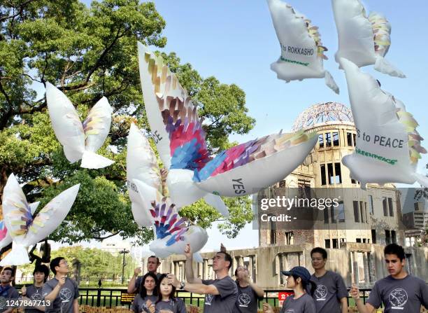 Environmental group Greenpeace members fly dove shaped paper balloons in the sky in front of the A-bomb Dome at Hiroshima's Peace Memorial Park 05...
