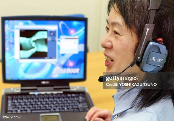 Japanese electronics giant Toshiba employee Junko Furuta displays the company's latest notebook computer "Dynabook G8" equipped with 2GHz-Mobile...