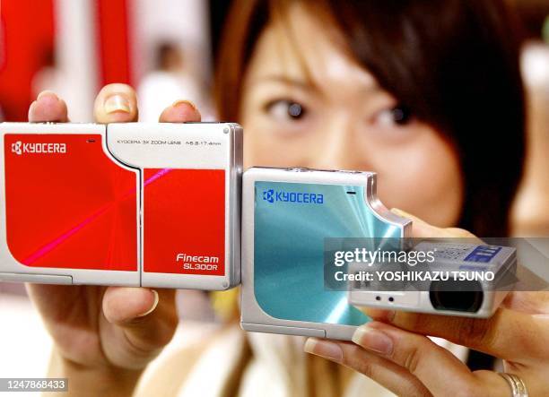 Employee for Japanese electronics giant Kyocera, Toshimi Fukuda, displays the new stylish digital camera "Finecam SL300R" equipped with a 3.17...