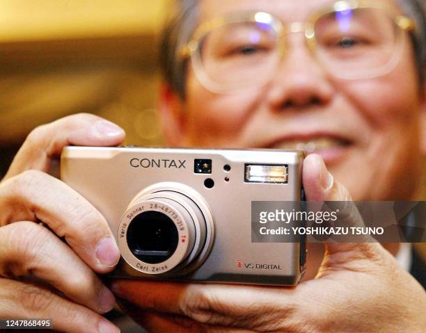 Yasuo Nishiguchi, President of Japan's Kyocera Corp, known as the Contax camera brand, displays the company's latest digital camera "Contax TVS...