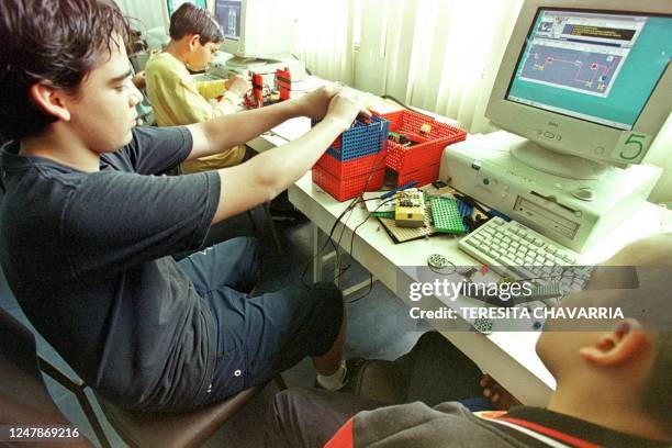 Abdres Lara , constructs an elevator using plastic pieces, 11 July 2002, during a class on robotics at the Fundacion Omar Dengo in San Jose, Costa...