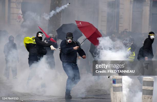 Protester protects himself with an umbrella from tear gas during a demonstration in Rennes, north-western France on March 7 on the sixth day of...