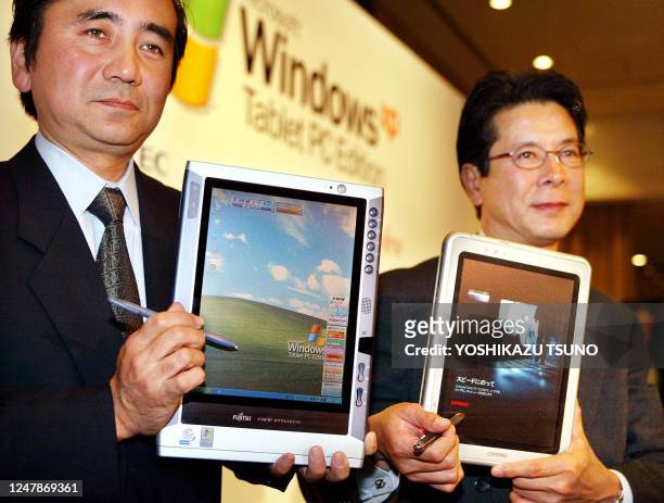 Japan's computer giant executive Kazuhiro Igarashi displays the new tablet PC Fujitsu's "FMV STYLISTIC TB80" while Japan Hewlett-Packard executive...
