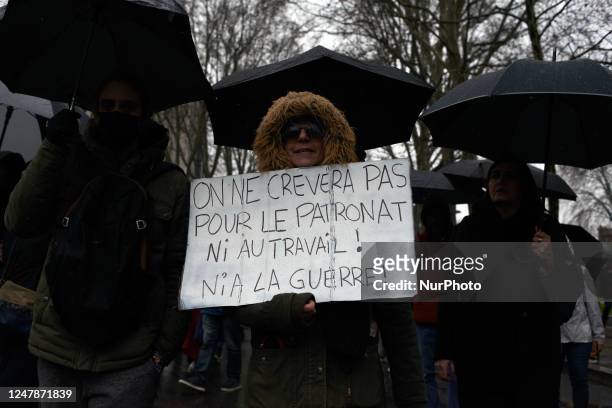 Woman holds a placard reading 'We won't be killed by bosses nor at work nor at war'. France's labour unions and left parties led a 6th wave of...