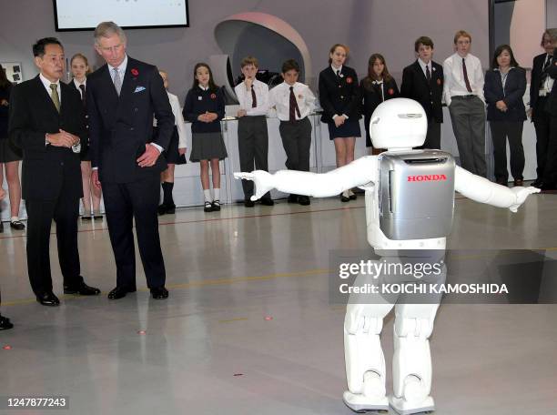 Britain's Prince Charles looks at Honda's humanoid robot "Asimo" during a visit to the National Museum of Emerging Science and Innovation in Tokyo on...