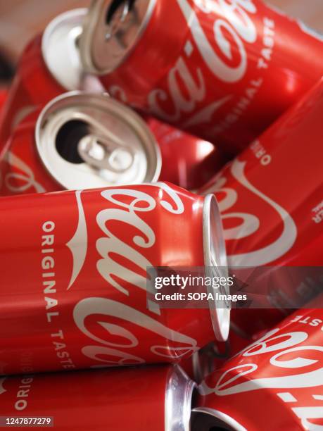 In this photo illustration, empty Coca-Cola cans seen displayed.