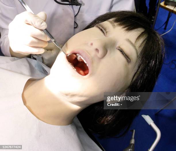 Japan's Nippon Dental University Hospital staff Yuko Uchida demonstrates a humanoid robot of dental therapy simulator "Simroid" for dentists and...