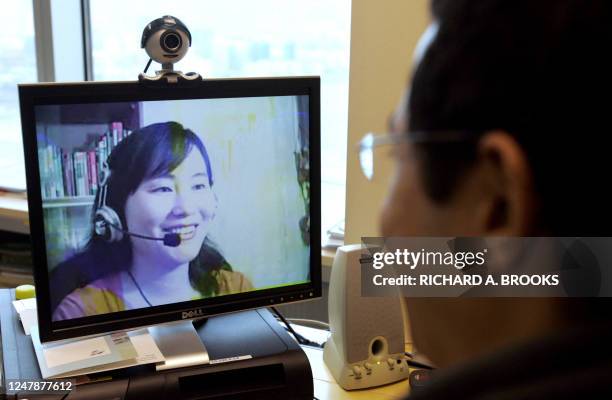 By GUY NEWEY - FILES - This picture shows a computer user in Hong Kong, 27 March 2007, looking at an image of online Mandarin teacher Lily Huang at...