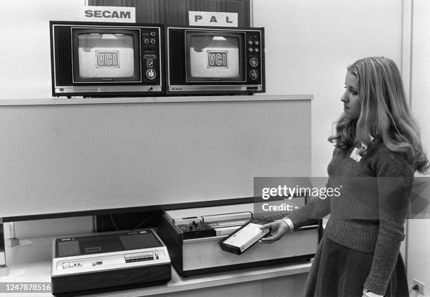 Photo datée du 23 janvier 1975 d'une personne introduisant une vidéo-cassette dans un magnétoscope, nouveauté technologique, qui ne tardera pas à...