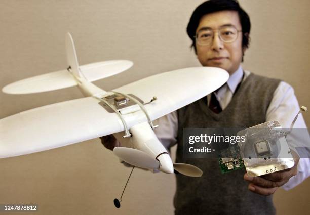 Japan's computer giant NEC researcher Akihisa Wada displays at the company's factory in Tokyo, 18 January 2005, a prototype model of an auto-pilot...