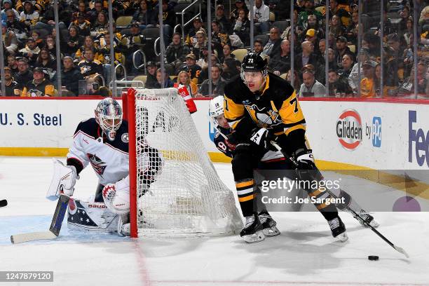 Evgeni Malkin of the Pittsburgh Penguins handles the puck against Elvis Merzlikins of the Columbus Blue Jackets at PPG PAINTS Arena on March 7, 2023...