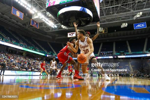 Hercy Miller of the Louisville Cardinals defends Quinn Pemberton of the Boston College Eagles during the ACC Tournament on March 7, 2023 at...