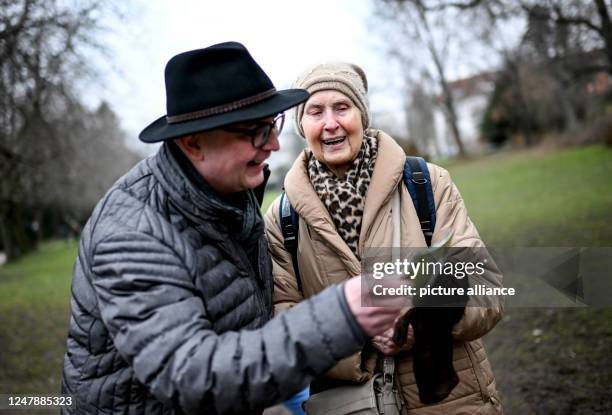 February 2023, Berlin: Helga Müller shows Jan Römmler an old photo during a walk. Under the motto "Young meets Old", the association "Friends of Old...