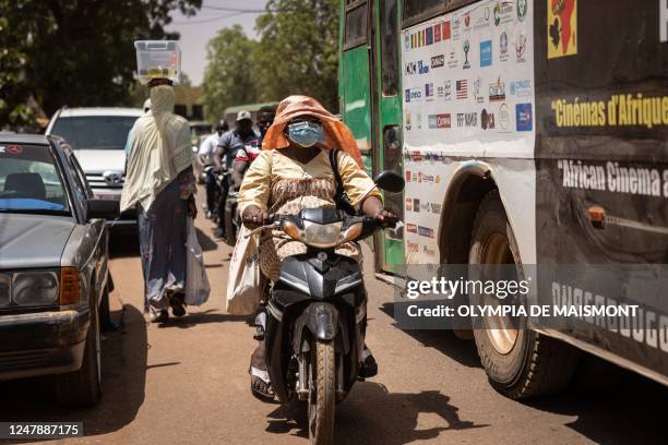 Woman rides a motorcycle in Ouagadougou, on March 2, 2023. - In Burkina Faso the motorcycle has already become a symbol of financial autonomy for...