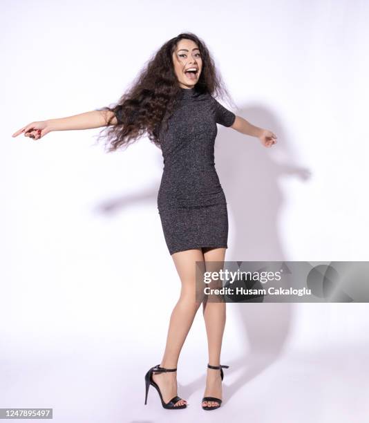 happy woman dancing with herself front of white background. - mini dress stock pictures, royalty-free photos & images