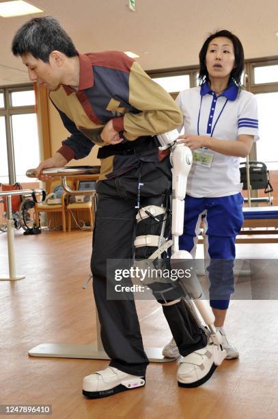 Japanese patient, paralysed on his left side, walks with the assistance of a Hybrid Assistive Limb during a rehabilitation session at a nursing home...