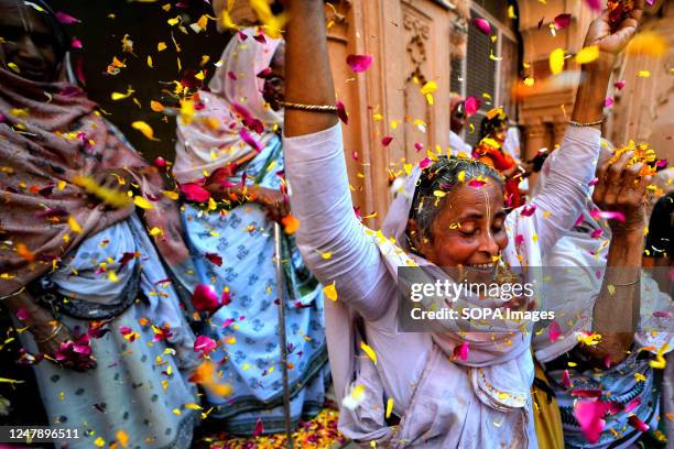 Indian Widows throw colorful flower petals at each other as they dance during a celebration of Holi or 'festival of colors' at Gopinath Temple in...